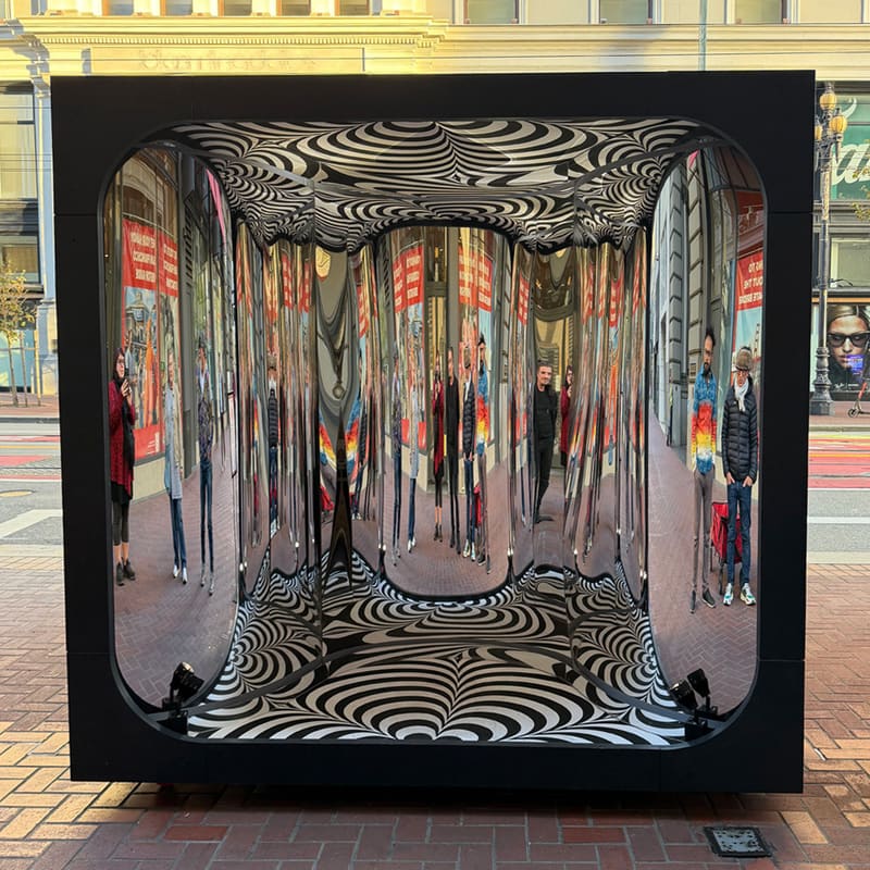 Silver Lining by Nico Corona and Rewina Beshue on Market Street: a black cube lined with mirrored walls between black and white op-art floor and ceiling, reflecting the street.