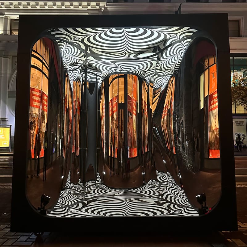 Silver Lining at night: the mirrored interior glowing with reflected shop lights between the op-art floor and ceiling.