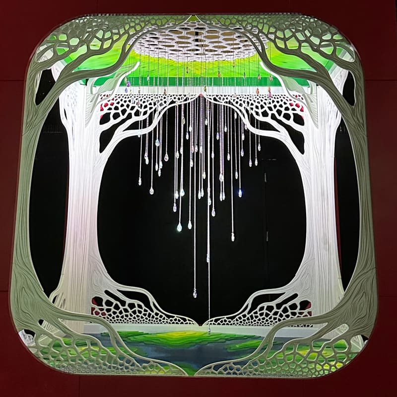 Water Torus at night: white carved trees framing strands of hanging crystals, lit from above.